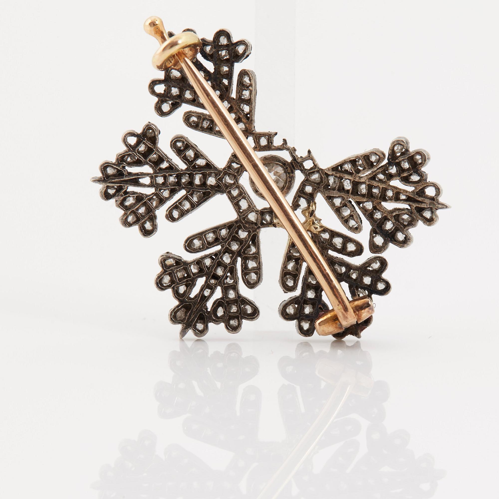 A brooch in the shape of a snow-flake by Fabergé, decorated with old and rose-cut diamonds.