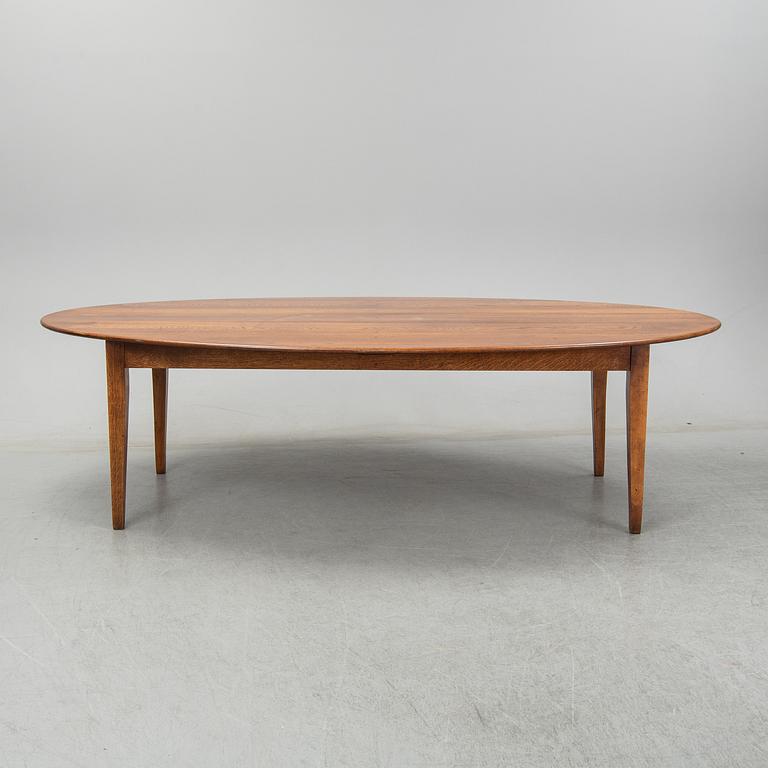 An stained oak dining table with eight chairs.