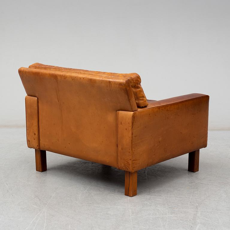 A 1960's/1970's leather covered easy chair with rosewood legs.