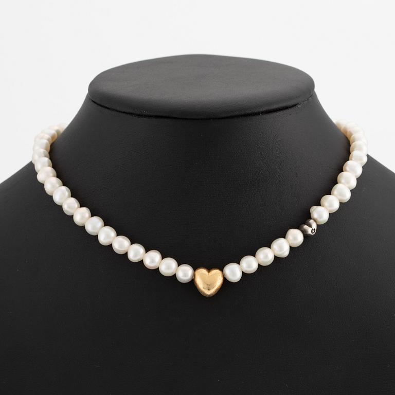 Ole Lynggaard 18K gold clasp in the shape of a heart with a cultured freshwater pearl necklace with a silver heart.