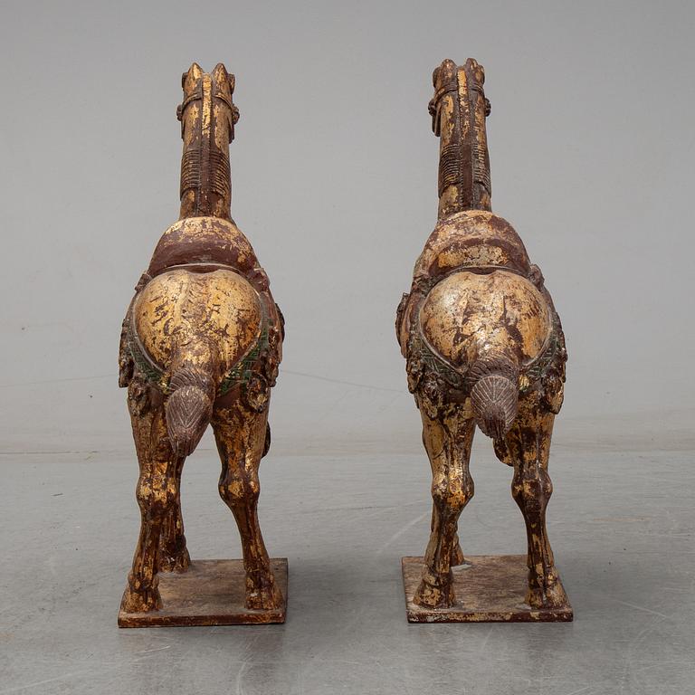 A pair of large Chinese wooden and gilt sculpture of horses, first half of the 20th century.