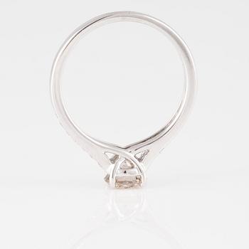 RING, 18K vitguld med briljantslipad diamant ca 0.70 ct samt små briljantslipade diamanter ca 0.10 ct. Vikt 2,9 gram.