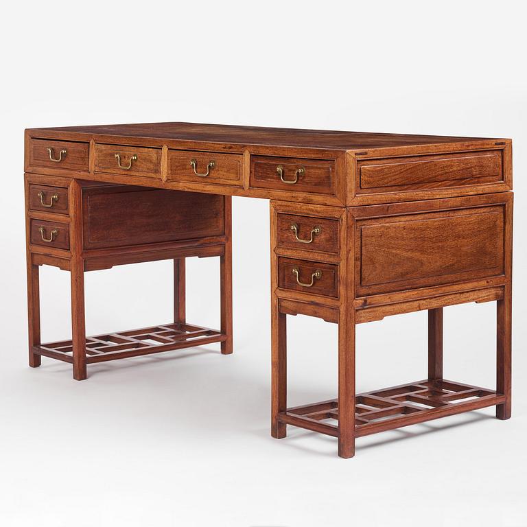 A six-drawer 'jichimu' pedestal partners desk, late Qing dynasty/early 20th century.