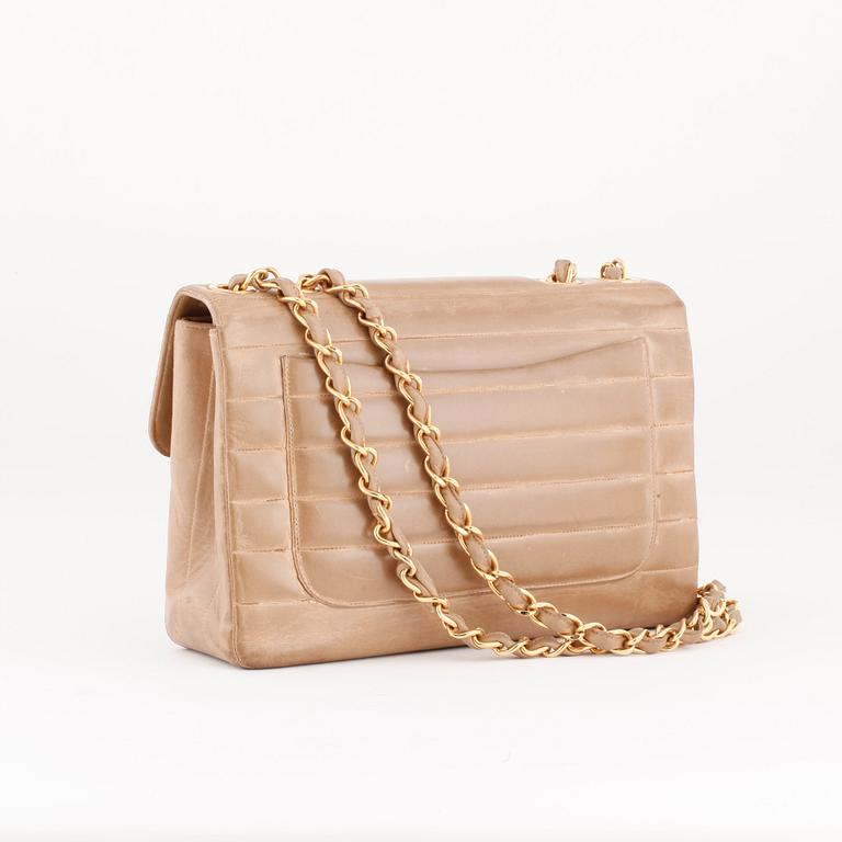 CHANEL, a beige leather flap bag.