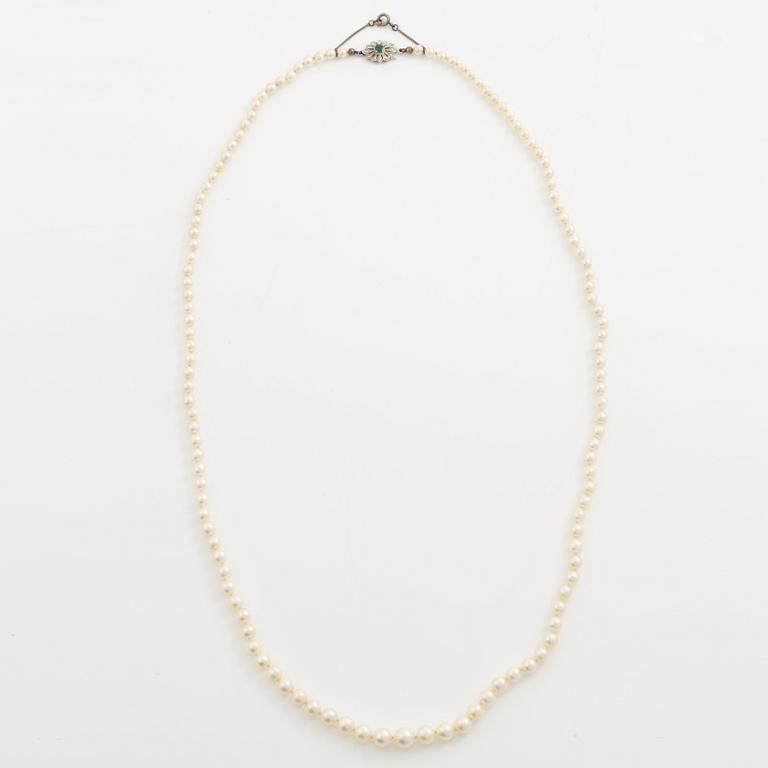 Necklace with graduated cultured pearls, with a clasp in 18K white gold set with an emerald.