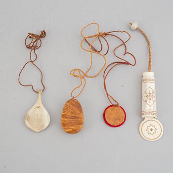Four Sami pendants, reindeer horn, birch and embroidery with silver thread, one signed TF for Torsten Fankki.