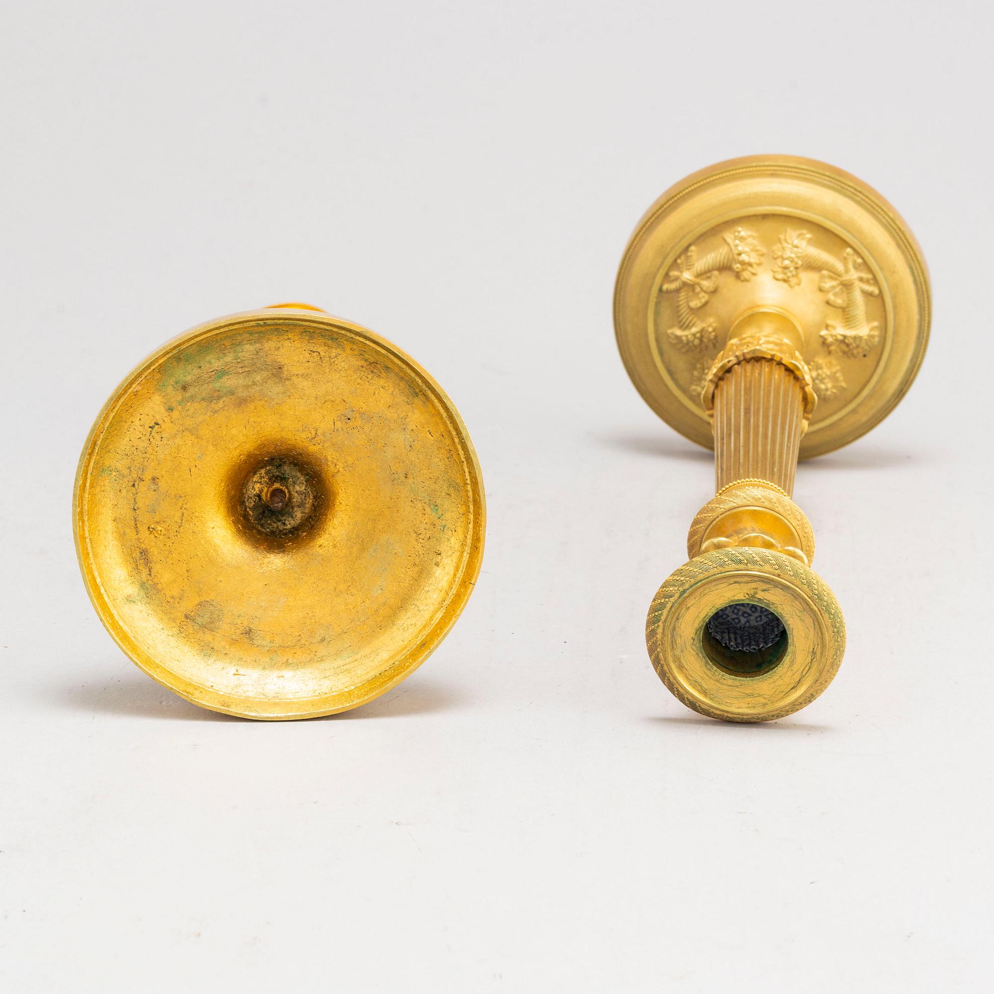 A pair of first half of the 19th century Empire candel sticks, gilded bronze, first half of the 19th century.