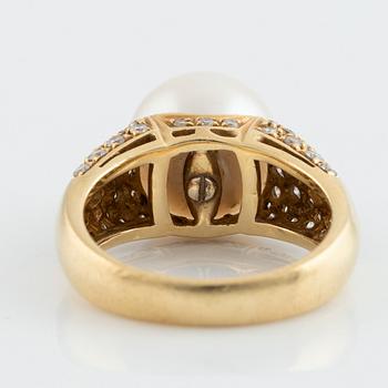 An 18K gold ring set with a cultured South Sea pearl and round brilliant-cut diamonds.