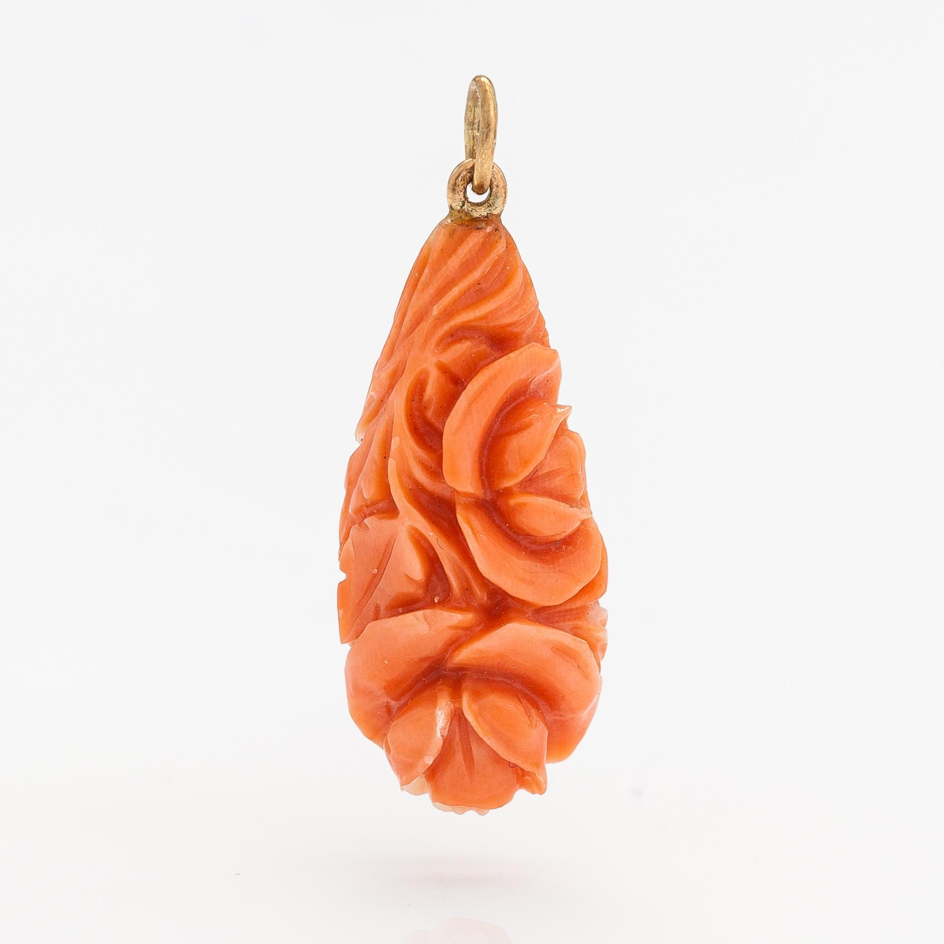 A pendant with carved coral and gold.