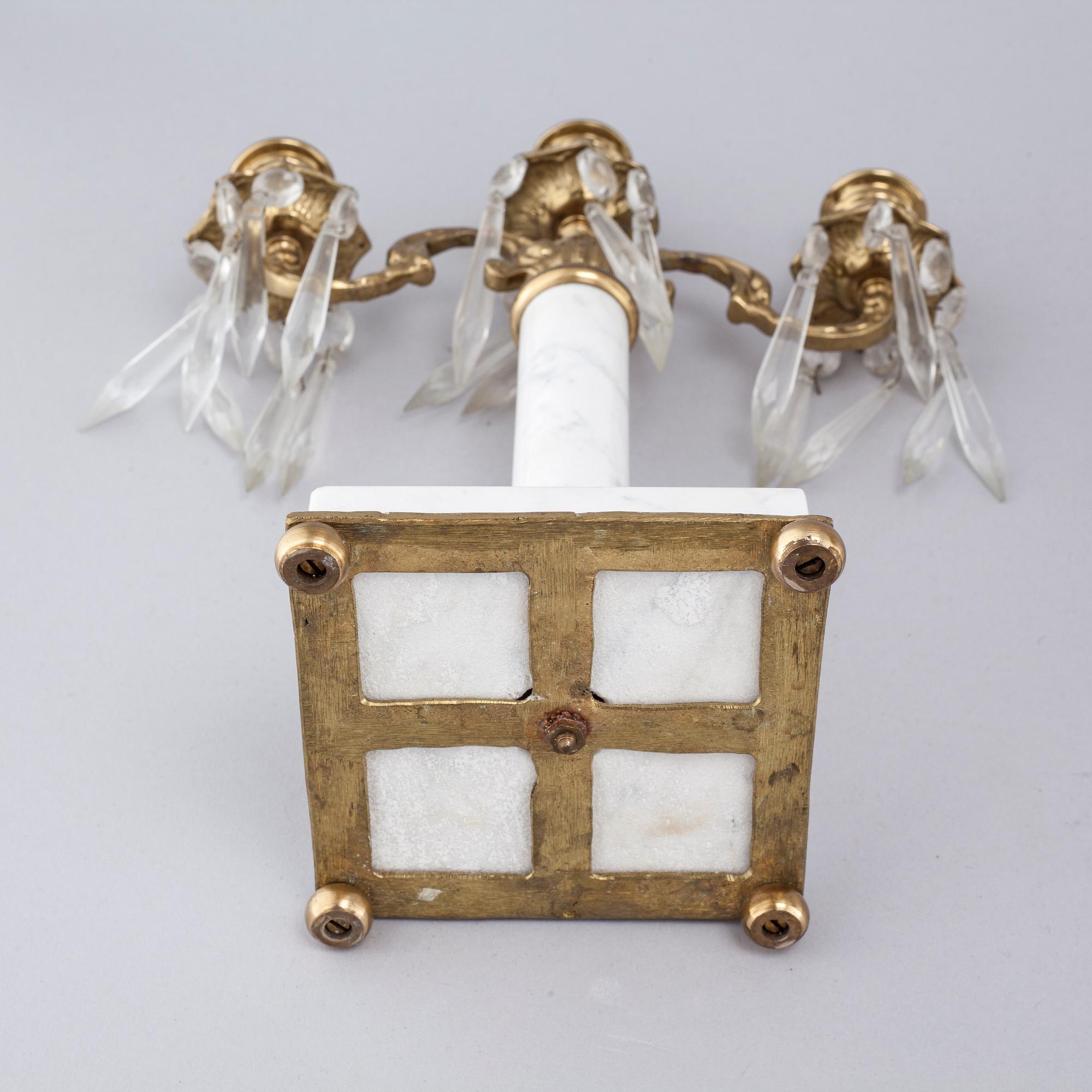 A French mantlepiece clock and a pair of candelabras, first half of the 20th century.