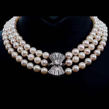 A NECKLACE, three strands of cultured pearls Ø 8 mm. Clasp in white gold and old cut diamonds c. 0.60 ct.