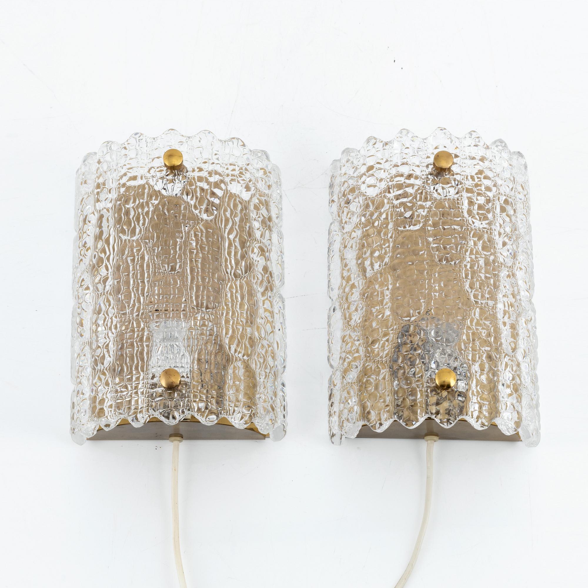 Carl Fagerlund, a pair of glass and brass wall lights, Orrefors, Sweden.