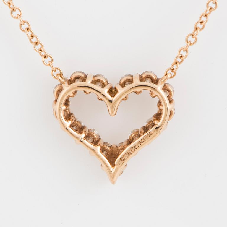 A Tiffany heart pendant in 18K rose gold set with round brilliant-cut diamonds.