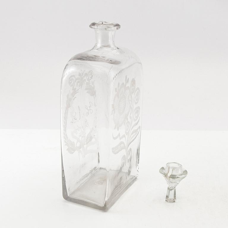 Brännvinsflaska, glas. Daterad Broby 1856.
