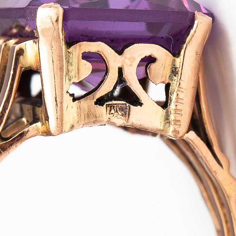 A 9-14K gold ring with a synthetic sapphire.