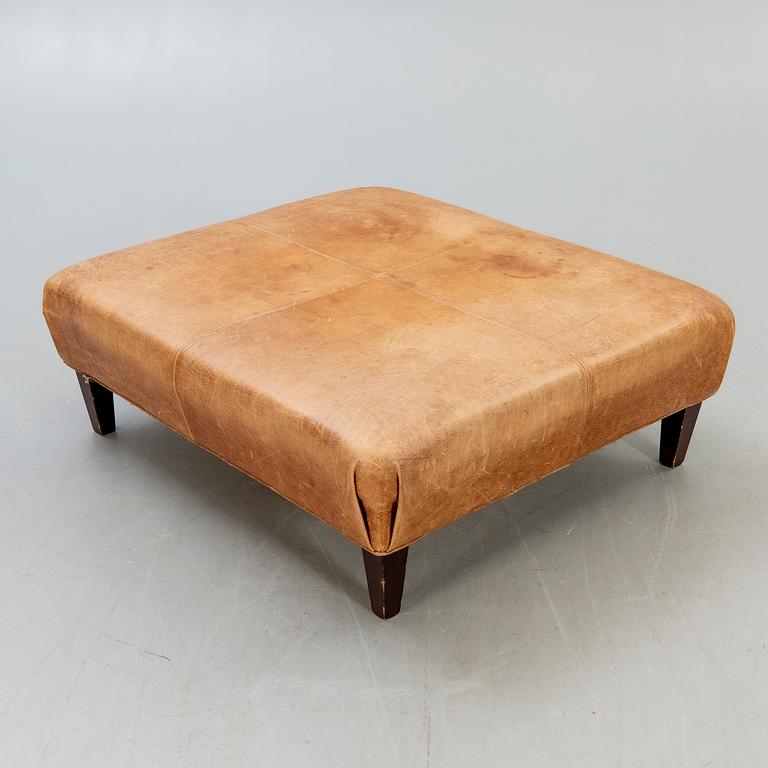 A leather ottoman/coffee table alter part of the 20th century.