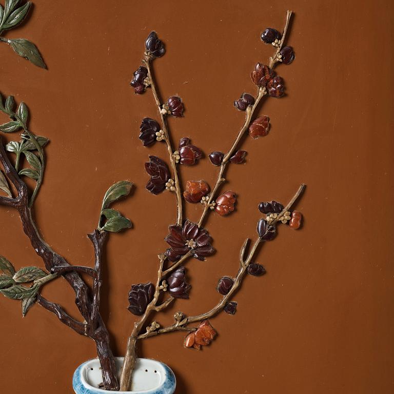 A lacquer wall panel with inlay of stone, cloisonné and porcelain, Qing dynasty, 19th Century.