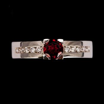 RING, vitguld 14K, fasettslipad granat 0,49 ct, briljantslipade diamanter diamanter tot. 0,21 ct. Vikt 4,7 g.