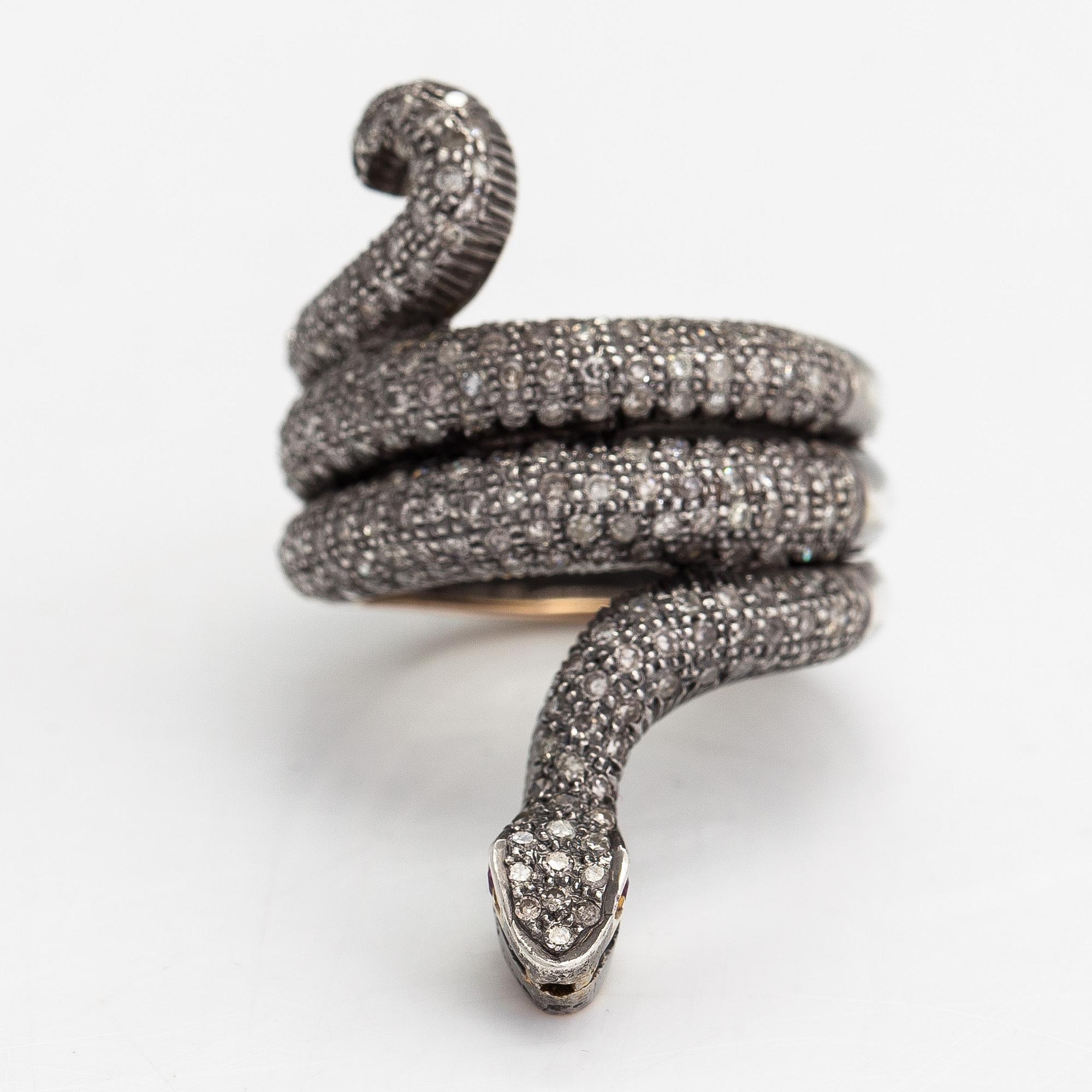 A serpent ring in gold and silver with rubies and single cut diamonds ca 0.88 ct in total.