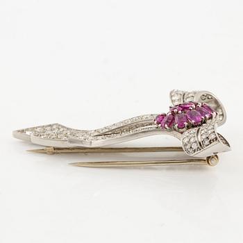 A brooch in platinum in the form of a bow with rubies and diamonds, likely from the 1950s.