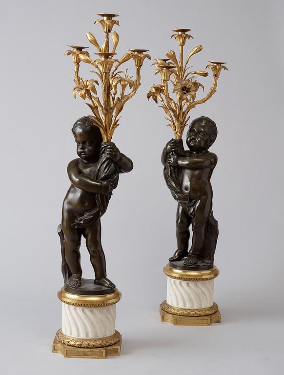 A pair of Louis XVI-style 19th century gilt and patinated bronze marble four-light candelabra.