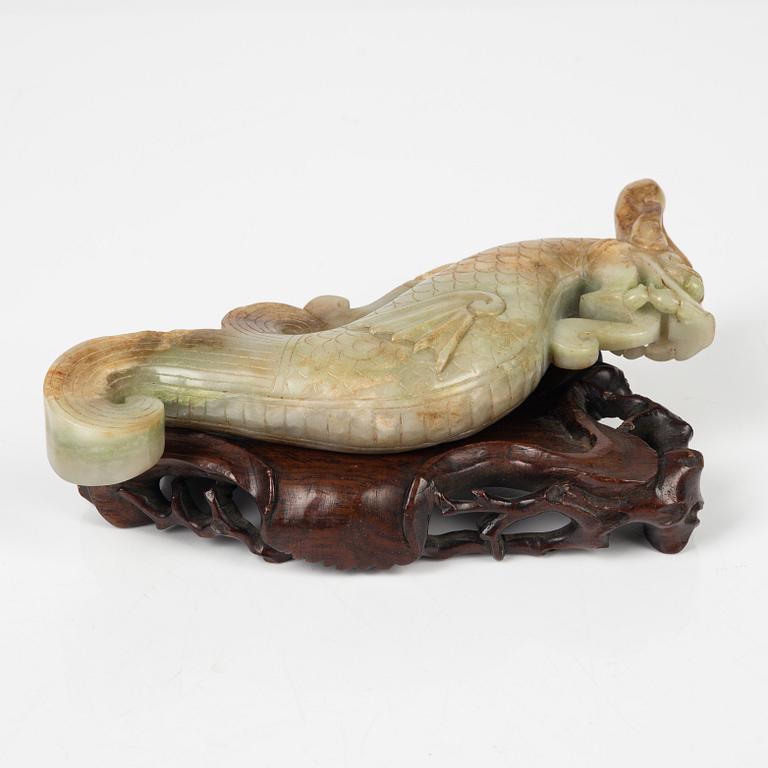 A Chinese nephrite sculpture on a wooden stand, 20th Century.