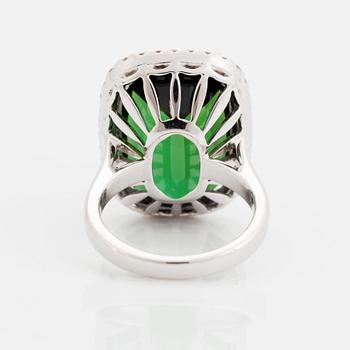 An 18K white gold ring set with a faceted green tourmaline and round brilliant-cut diamonds.