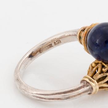 An Ilias Lalaounis demi parure comprising a necklace, a bracelet and a ring in silver and 18K gold set with sodalite.