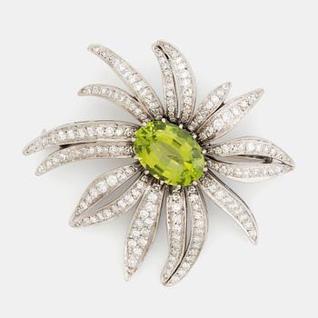 487. An 18K white gold brooch set with a faceted peridot and eight-cut diamonds.