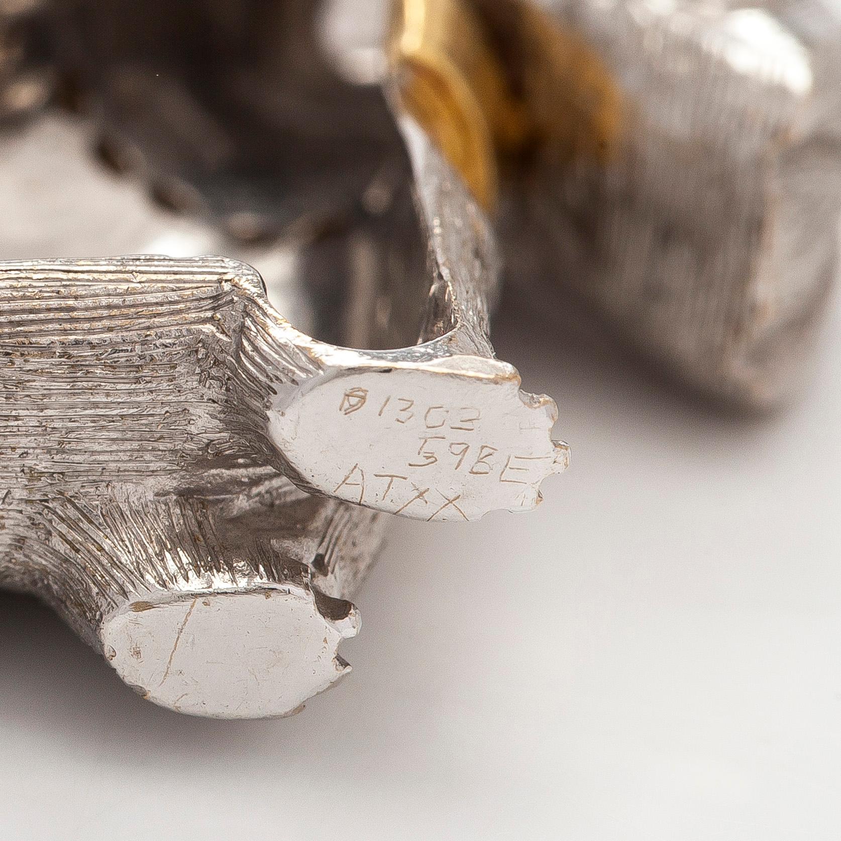 Rintaneula, 18K valkokultaa, sekä granaatteja ja briljanttihiottuja timantteja. BW&Co, Lontoo.