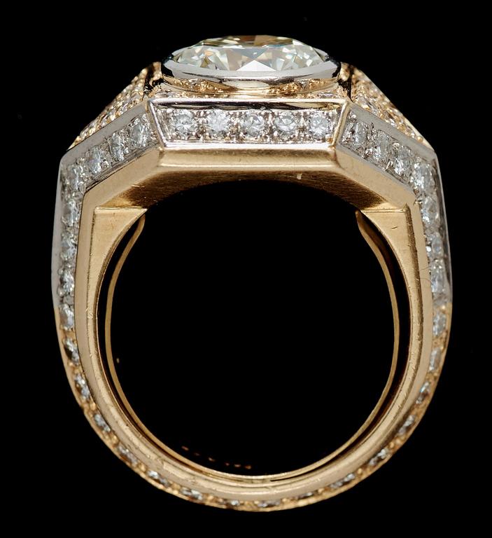 RING, 18k guld med briljantslipad diamant ca 2.95 ct, omgärdad av mindre briljantslipade diamanter totalt ca 1.50 ct.