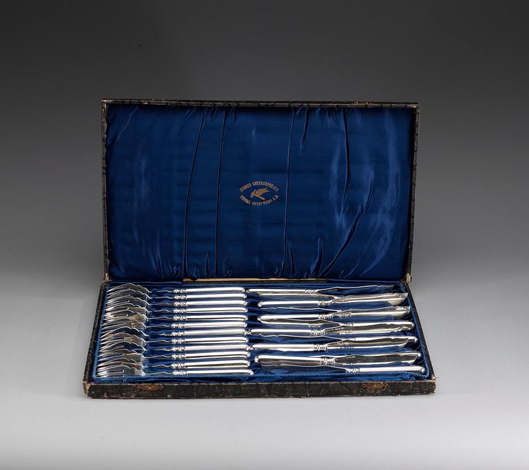 A Russian set of 24 silver fish forks and knivs, makers mark of Mikhail Grachev, St. Petersburg 1908-1917.