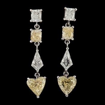 1038. A pair of fancy yellow and colourless diamond earrings.