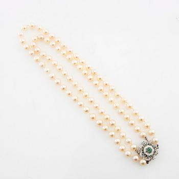 Necklace double-stranded of cultured pearls with a clasp of 18K white gold and emeralds.