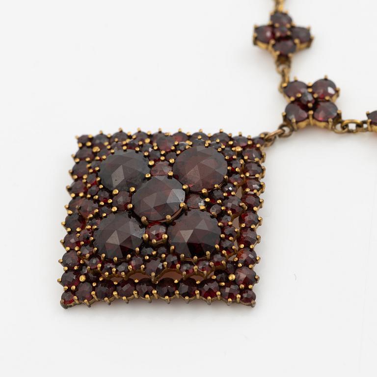 Pendant and a pair of earrings, gilt metal with garnets.