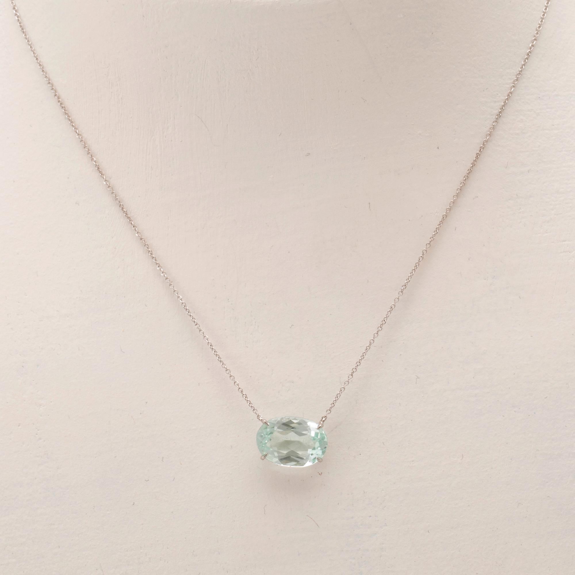 An 18K white gold necklace with an oval faceted aquamarine.