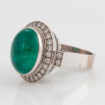 An 18K white gold ring set with a cabochon-cut emerald and round brilliant-cut diamonds.