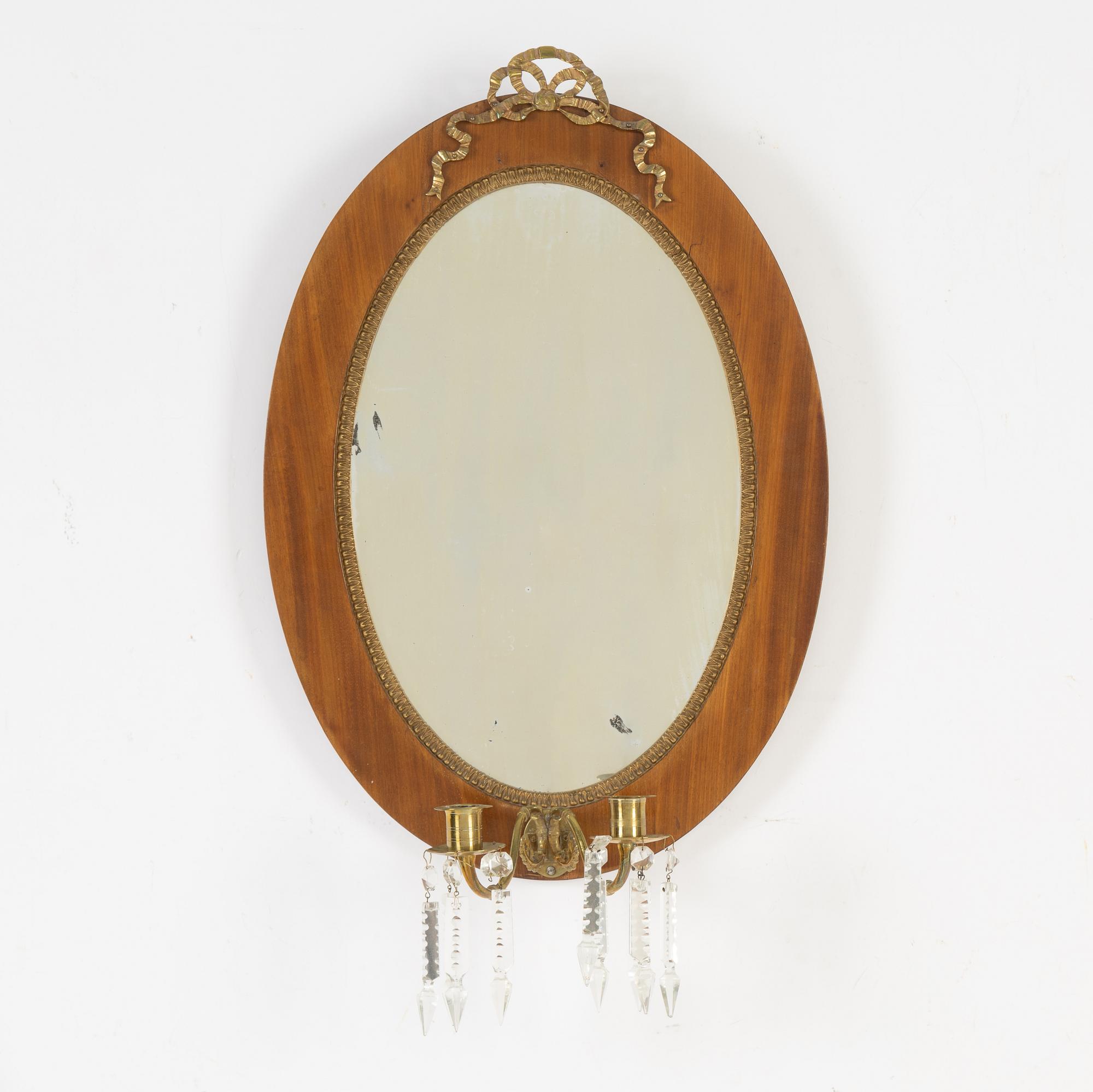 A mahogany veneered mirror sconce, Empire style, around 1900.