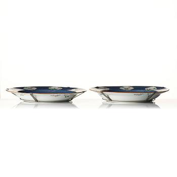 A fine pair of large powder-blue-ground famille-verte 'flowering garden' dishes, Qing dynasty.