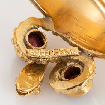 An 18K gold ring set with cabochon-cut garnets design Ilias Lalaounis.