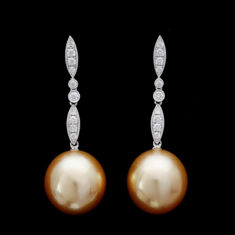 EARRINGS, cultured golden South sea pearls, 13 mm, briliiant cut diamonds , tot. app. 0.40 cts.