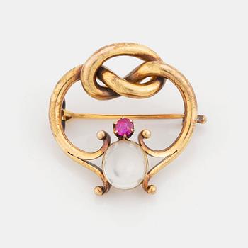 538. A 14K gold brooch set with a cabochon-cut moonstone and a pink sapphire.