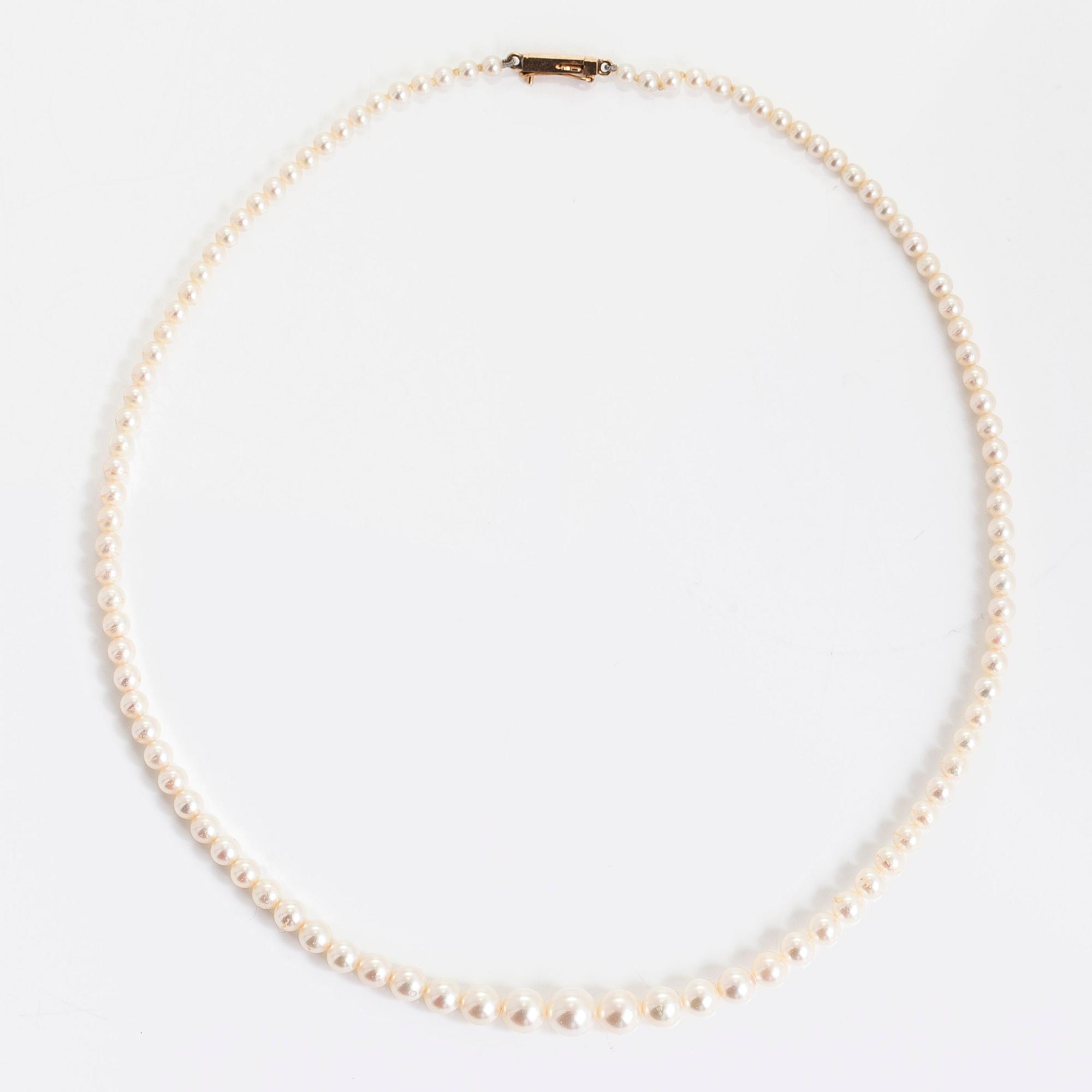 A graduated cultured pearl necklace, clasp in 14K gold.