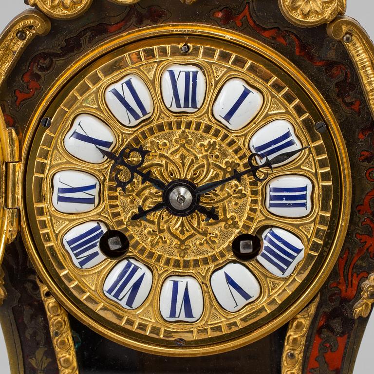 A Louis XV-style mantle clock with console base.