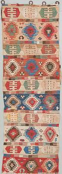 An antique Anatolian kilim fragment in form of a drape, around 232 x 76 cm.