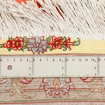 A Täbriz rug, signed, part silk, 210 x 148 cm.