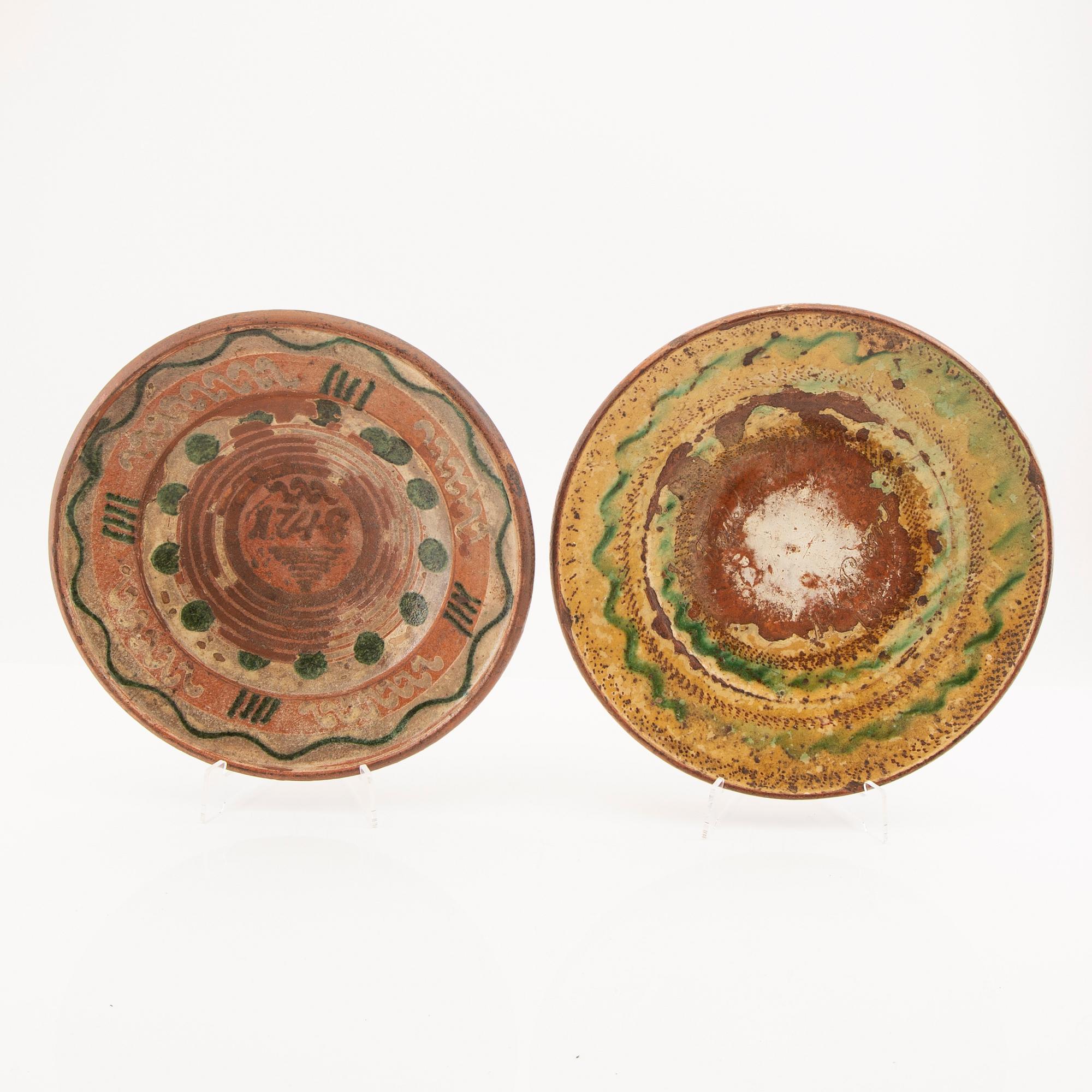 Two bowl plates ("Äggakagefat") 2 pieces from Skåne, one dated 1748 and 1891, engobed earthenware.