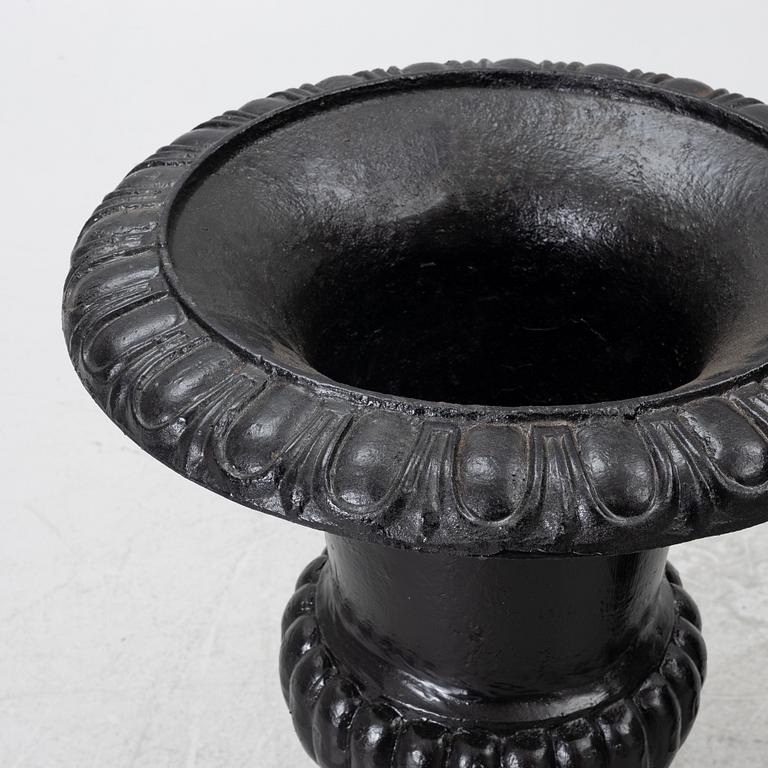 A pair of cast iron garden urns, 20th century.