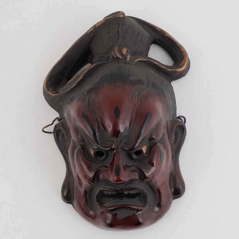 A Japanese lacquered wooden mask, 20th century. Signed.