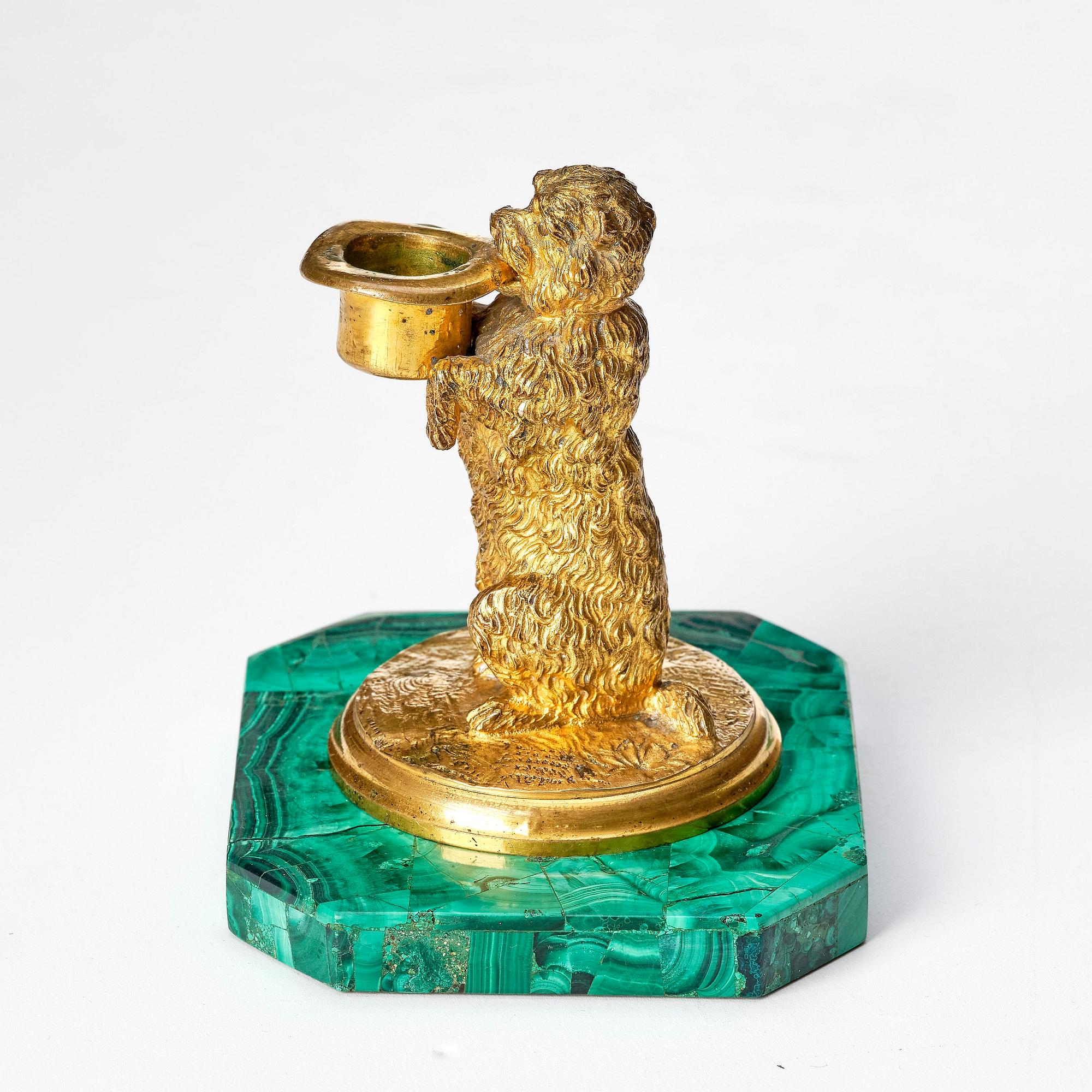 A Russian Nicholas II malachite-veneered and gilt-bronze candlestick, late 19th century.